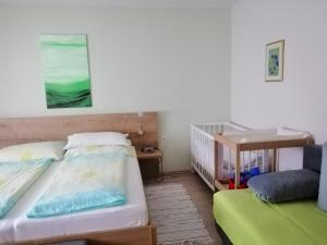 ein Schlafzimmer mit 2 Betten und einem Kinderbett in der Unterkunft Campingblick-Gästehaus-Ferienwohnungen in Podersdorf am See