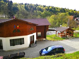 a blue car parked in front of a house at Cabana Rustic Balea in Cîrţişoara