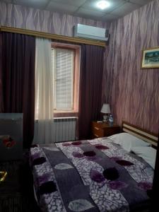 ein Schlafzimmer mit einem Bett mit einer Decke darauf in der Unterkunft AZPETROL HOTEL GAZAX in Qazax