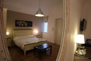 um quarto com uma cama, uma mesa e um candeeiro em Federico Secondo B&B em Palermo