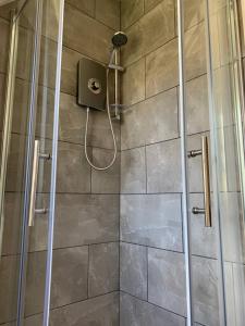 a shower with a glass door and a shower at Royal Mile Balconies by the Castle in Edinburgh