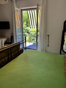 a bedroom with a green bed and a sliding glass door at B&B Massico Apartments in Sant'Agnello