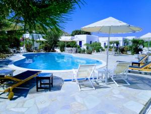 a swimming pool with chairs and an umbrella at Onira in Parikia