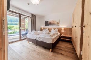 a bedroom with a large bed and a large window at B&B - Rooms&Apartments Oberwiesen in Brunico +87 photos