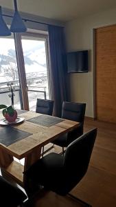 ein Esszimmer mit einem Tisch, Stühlen und einem Fenster in der Unterkunft Appartement Mountainview in Saalbach-Hinterglemm