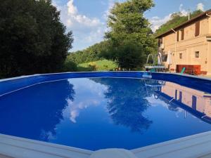 a blue swimming pool with a reflection in the water at Armonia della Sera B&B - Residenza di campagna in Porto SantʼElpidio