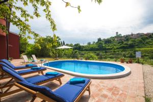 a pool with chaise lounge chairs and a swimming pool at Villa Mamma Mia Oprtalj in Oprtalj