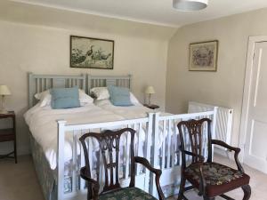 1 dormitorio con 1 cama grande y 2 sillas en Billerwell B&B, en Hawick