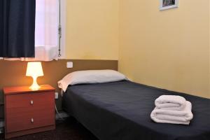 ein Schlafzimmer mit einem Bett mit zwei Handtüchern darauf in der Unterkunft Hostal Bejar in Barcelona + 18 Fotos