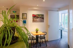 a table and chairs in a room with a plant at Hotel de la Tour in Paris