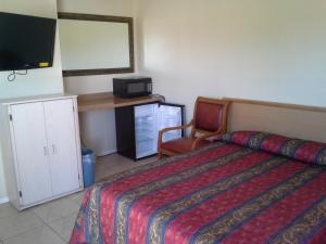 Habitación de hotel con cama y TV en Boron Motel, en Boron