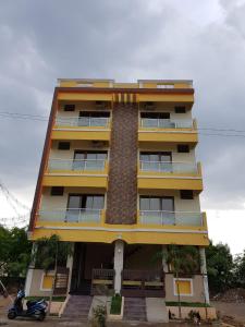 a tall yellow building with a scooter in front of it at Siva Giri Homes in Tiruvannāmalai