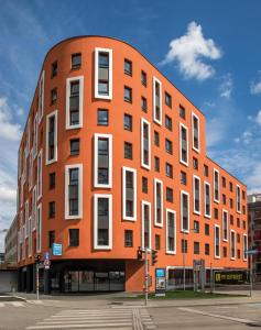 an orange building with white windows on a street at SMARTments business Wien Hauptbahnhof - Serviced Apartments in Vienna