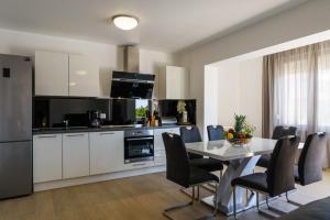 een keuken en eetkamer met een tafel en stoelen bij Apartments Apollo in Trogir