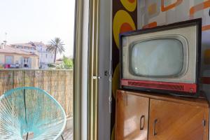 an old tv sitting on a dresser next to a window at Studio proche plage et croisette in Cannes