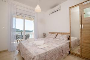 a bedroom with a bed with a view of the ocean at Apartments Lavanda in Neum