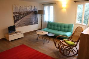 ein Wohnzimmer mit einer grünen Couch und einem Tisch in der Unterkunft La Romarine in Falicon