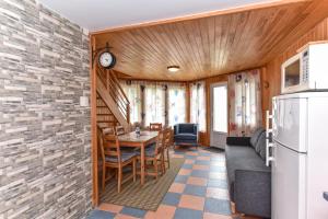 a kitchen and dining room with a table and a refrigerator at Kotedžiukai Šventojoje in Šventoji