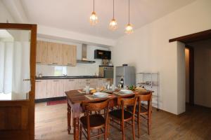 uma cozinha com uma mesa de madeira e cadeiras num quarto em Podere I Gigli em Castiglion Fiorentino