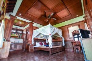 een slaapkamer met een hemelbed bij Nick's Pension in Ubud