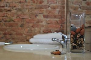 lavabo con jarrón de cristal lleno de rocas en Apartamentos Bejar en Barcelona