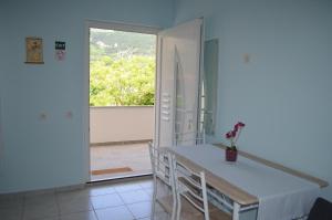 comedor con mesa, sillas y ventana en Apartments Alen, en Draga Bašćanska