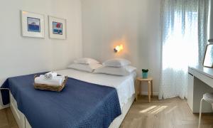 - une chambre blanche avec un lit et un panier dans l'établissement 17 Pines, à Makarska