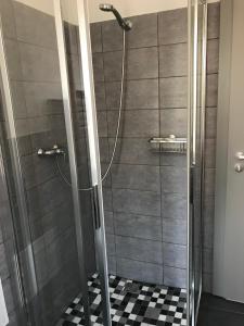 een douche in een badkamer met een zwart-wit geruite vloer bij Apartmán Havlíčkova in Karlsbad
