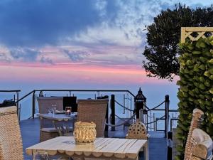 a table and chairs on a deck with a view of the ocean at Petani Bay Hotel - Adults Only in Vóvikes