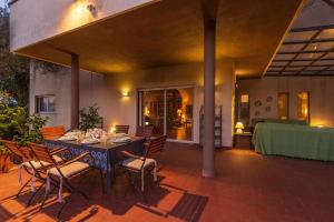 a dining table and chairs on a patio at Domus Sicily - Villa Conca d'Oro with Pool in Palermo
