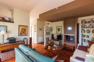 a living room with a couch and a tv at Domus Sicily - Villa Conca d'Oro with Pool in Palermo