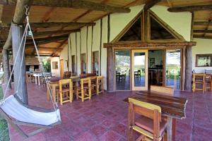 a room with a porch with chairs and a swing at Ecoposada del Estero in Colonia Carlos Pellegrini