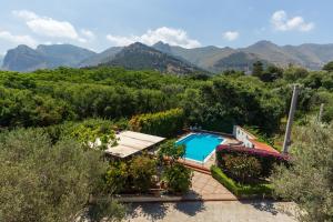a pool in a garden with mountains in the background at Domus Sicily - Villa Conca d'Oro with Pool in Palermo