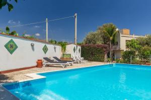 a swimming pool with two lounge chairs next to a house at Domus Sicily - Villa Conca d'Oro with Pool in Palermo