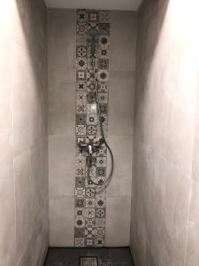 a shower in a bathroom with a tile wall at Vistas de Lisboa Hostel in Lisbon