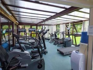 a gym with a row of treadms and cardio machines at Pantglas Hall Holiday Lodges and Leisure Club in Carmarthen