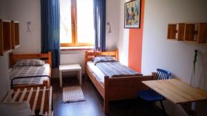 Krasnogruda的住宿－Pokoje Gościnne "Szkoła"，一间卧室设有两张床、一张桌子和一个窗口