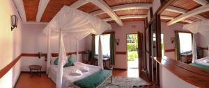 um quarto com uma cama de dossel numa casa em Kongoni Camp em Nanyuki