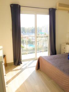 um quarto com uma cama e uma grande janela em Thalassa Sea View Suite em Limassol
