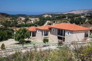 a house with an orange roof on a hill at Maspali Apartments in Lixouri