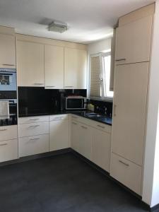 uma cozinha com armários brancos e electrodomésticos pretos em Top of Brig em Brig