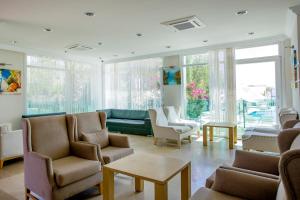 a waiting room with chairs and a couch and windows at Dragut Point North Hotel - All Inclusive in Turgutreis