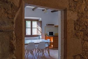 eine Küche und ein Esszimmer mit einem Tisch und Stühlen in der Unterkunft Can Gich Espacio Rural in Celrá
