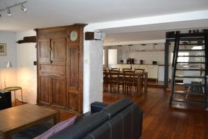 a living room with a couch and a clock on a wall at Gitesonoro Beho in Gouvy +28 photos