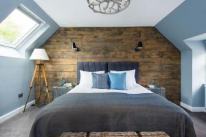 um quarto com uma cama grande e uma parede de madeira em The Kilchrenan Inn em Oban