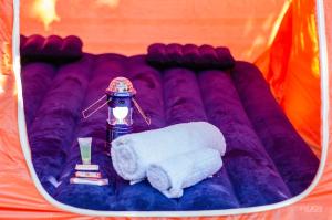 una manta púrpura con cepillo de dientes y toalla en Camp'in Goris en Goris