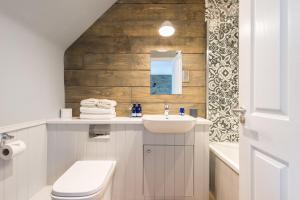 a bathroom with a sink and a toilet and a mirror at The Kilchrenan Inn in Oban +30 photos