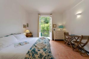 a bedroom with a bed and a table and a window at ALTIDO Lovely Apt for 2, with Terrace in Vernazza in Vernazza