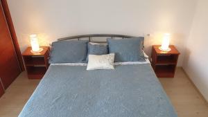 a bedroom with a blue bed with two night stands at Apartment Marina in Valun