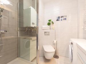biała łazienka z toaletą i prysznicem w obiekcie VacationClub - Pionierów 6, Apartament 25 w mieście Mielno +3 zdjęcia